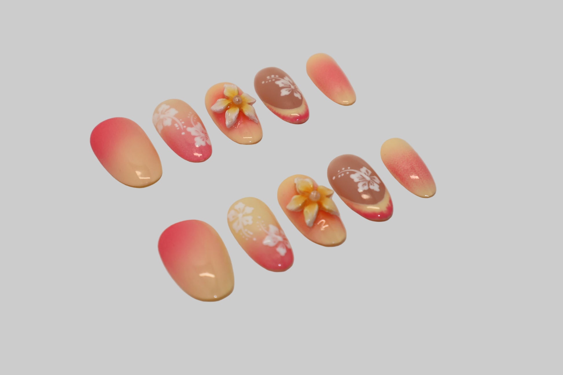 Set of nails with 3D floral designs on a white background