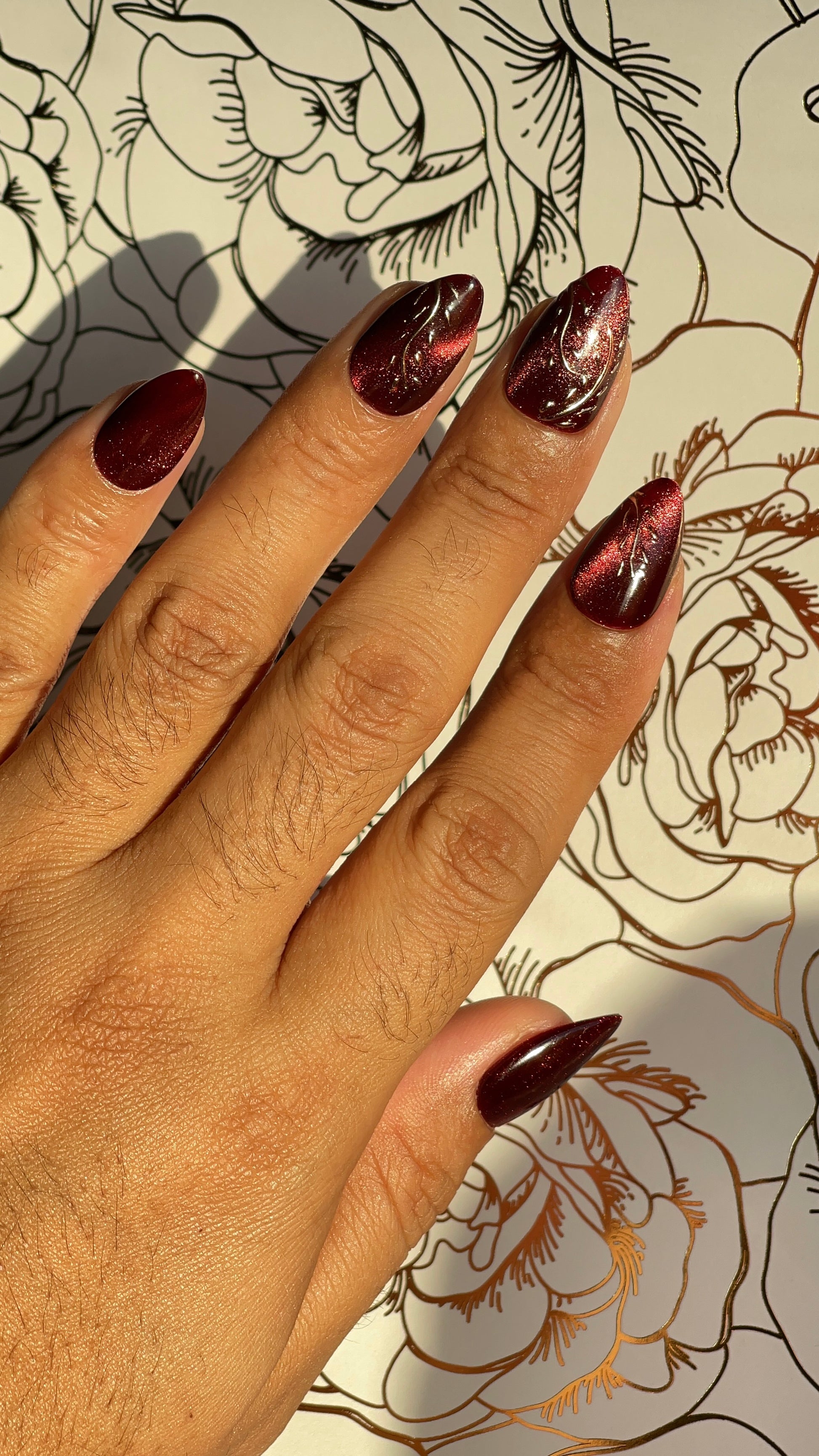Deep red Cat eye press-on nails with golden accents. Inspired by glowing embers and winter warmth — for bold, grounded beauty.
