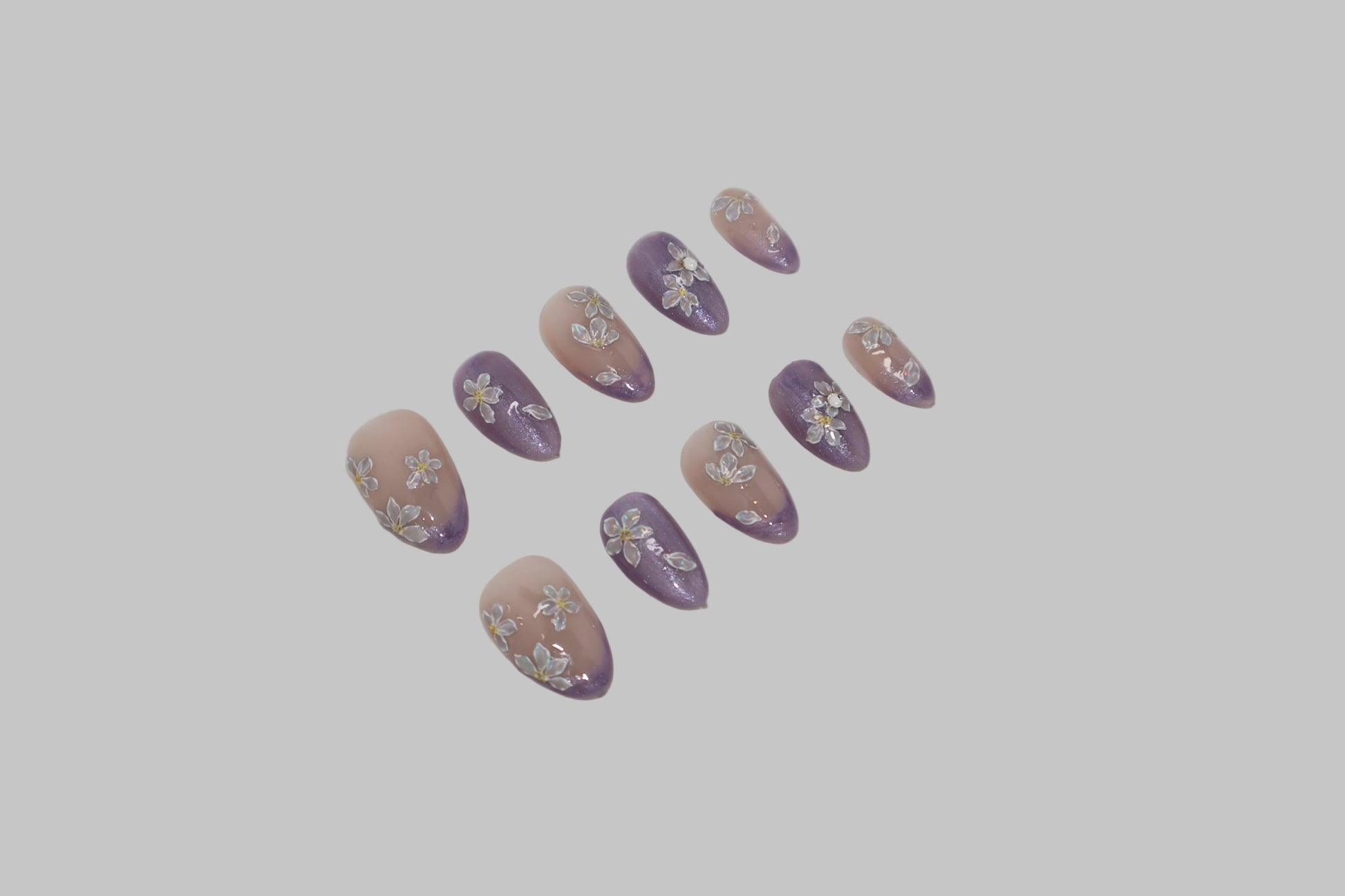 Set of purple and nude nail art designs on a white background